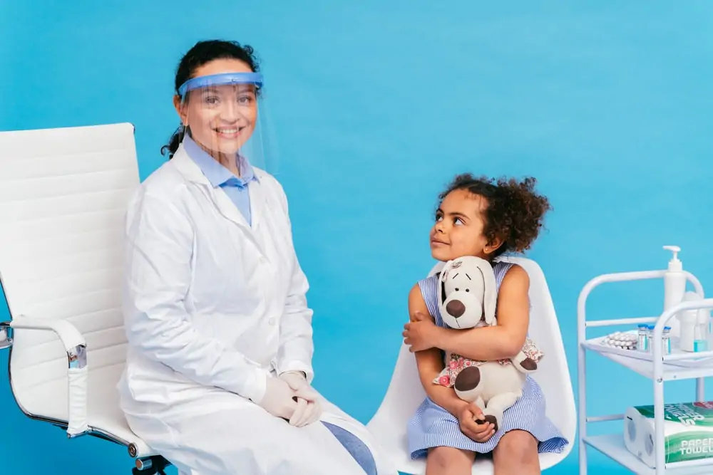 female doctor examining kid patient