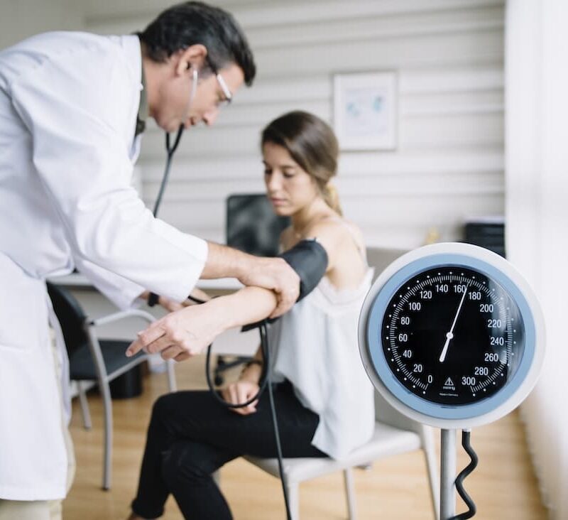 doctor checking blood pressure of patient