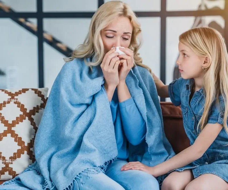 Little cute girl sitting with her sick mother