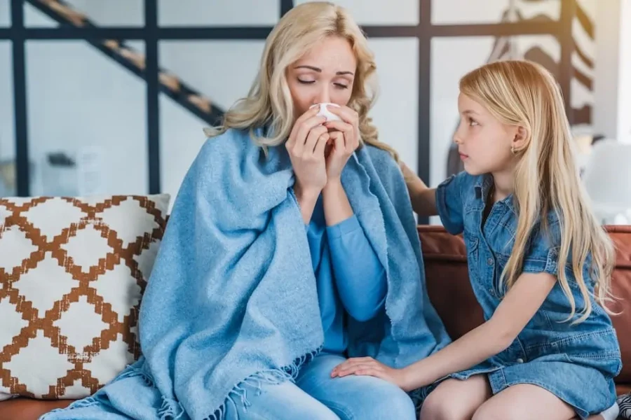 Little cute girl sitting with her sick mother