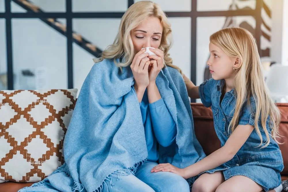 Little cute girl sitting with her sick mother
